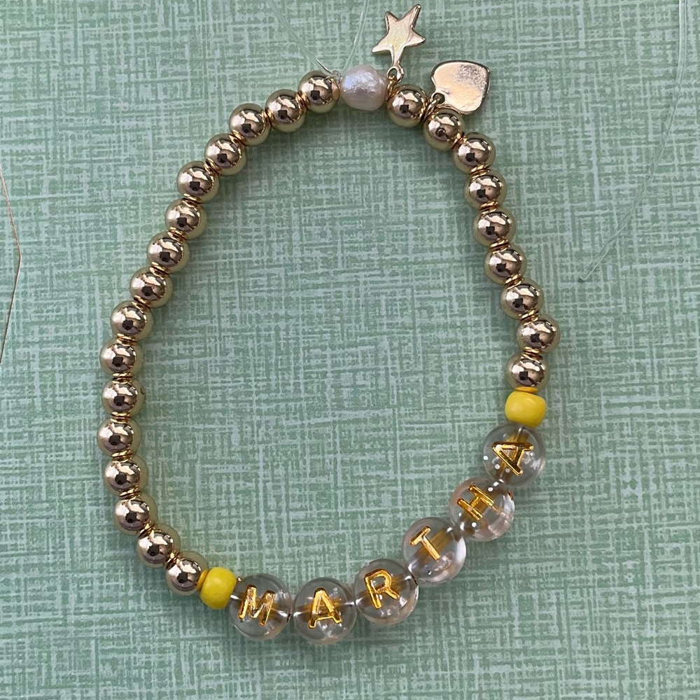 Customized 14k gold plated bracelet. Adorned w/ charms & real pearl.